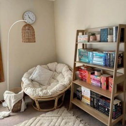 a room with books on a shelf and a chair