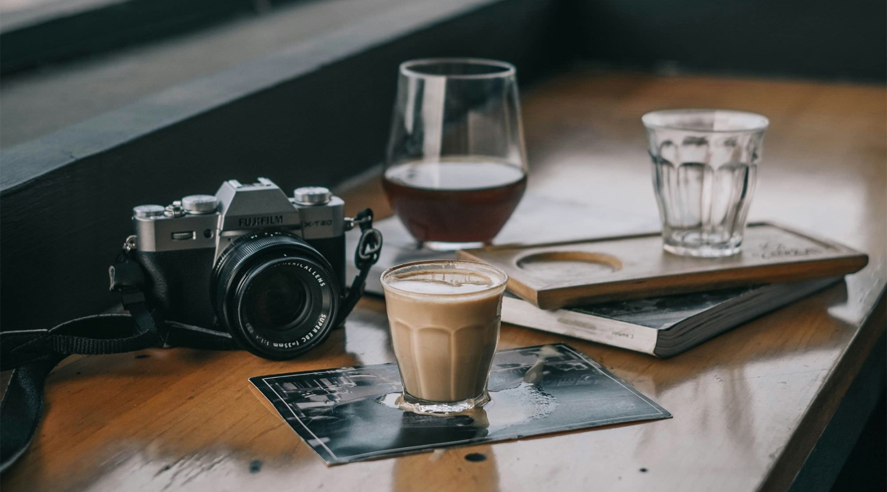 a table with drinks, books and a camera