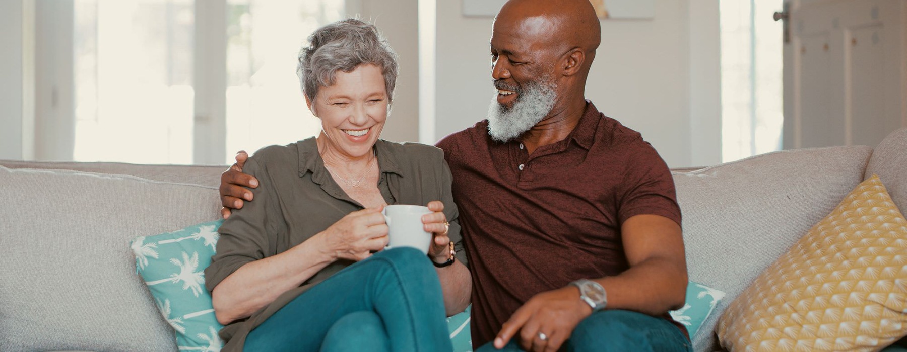 smiling, older couple, sit together on a couch